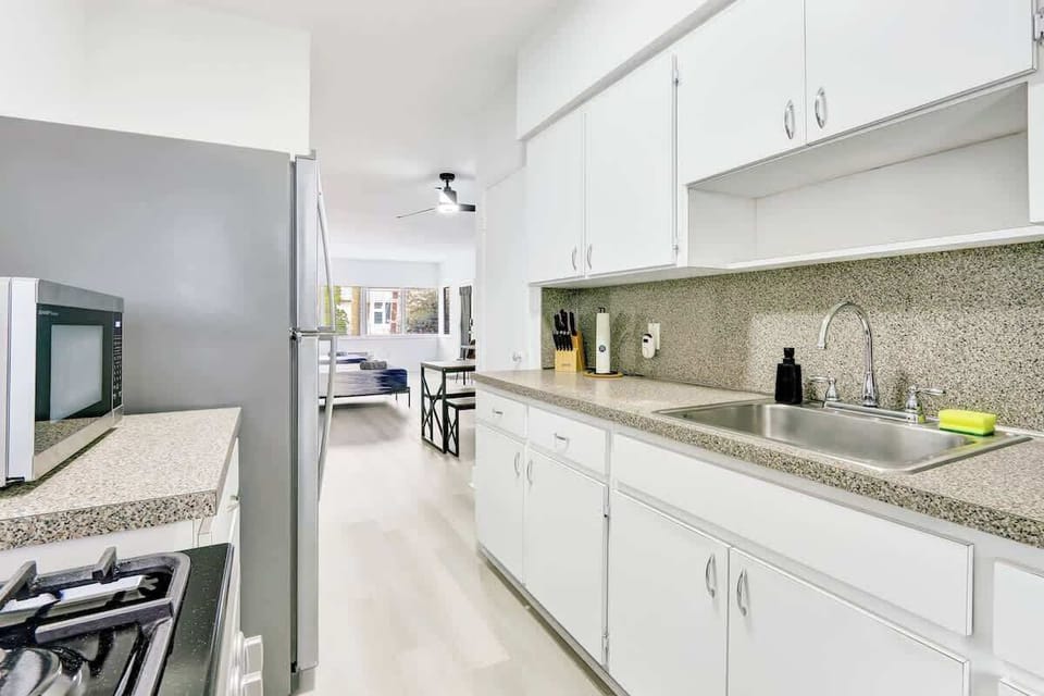 Fully equipped kitchen with fridge, stove, microwave, and cookware, ready for home-style meals.