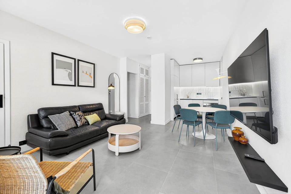 Modern Open-Concept Living Room with Smart TV, Dining Area & Fully Equipped Kitchen