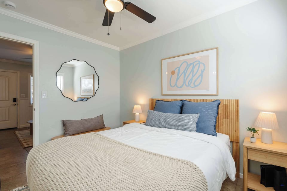 Comfortable queen bedroom with nightstands, lamps, and closet storage.