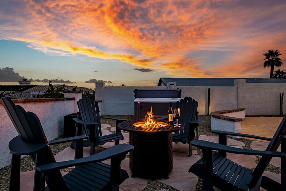 Outdoor Terrace: Warming fire pit, Cozy seating, and hot tub. Experience the magic of a desert sunset from your own private sanctuary.