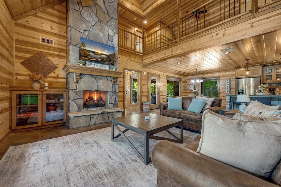 Cozy great room with soaring ceilings and a stunning stone fireplace