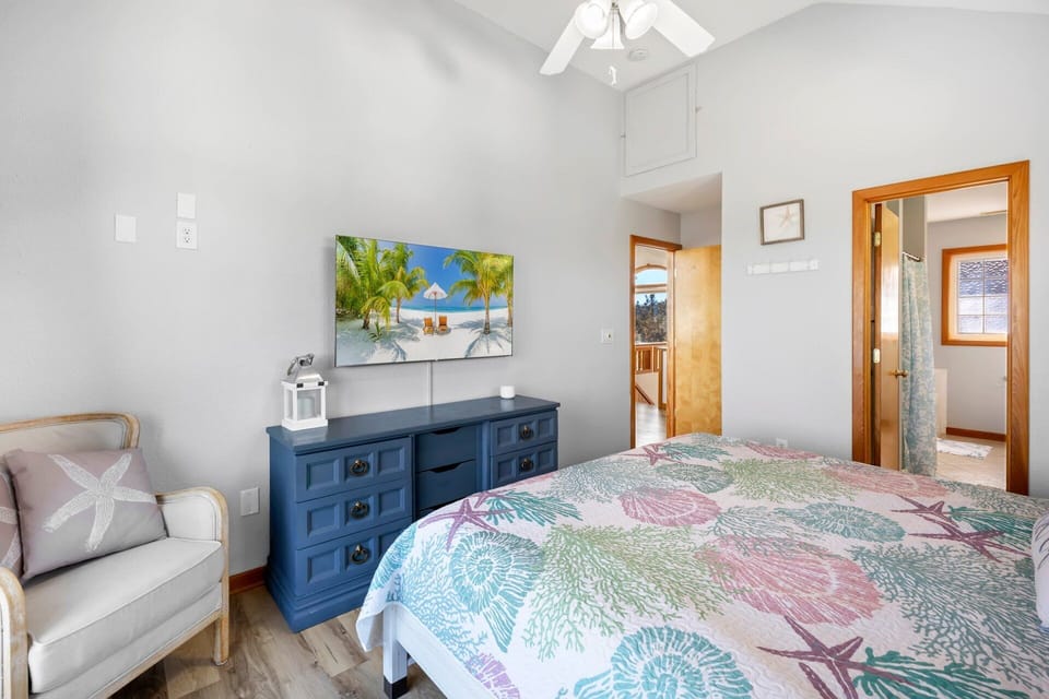 The top-level King ensuite bedroom offers a private retreat with deck access and serene coastal ambiance.