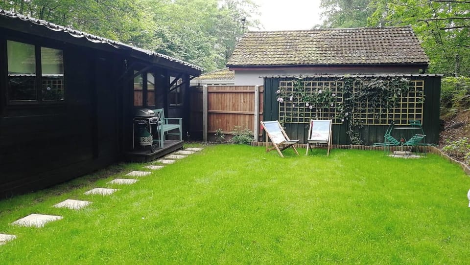 Small private garden which is private but not completely closed off due to the parking space