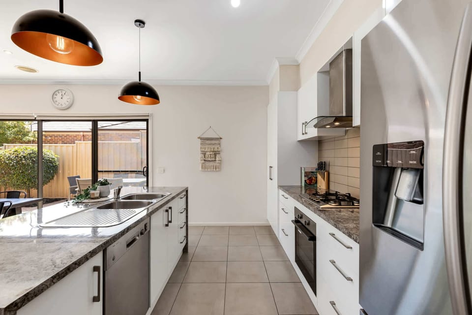 Open plan kitchen, the heart of the home, featuring a large island bench, stainless steel appliances and a coffee pod machine.