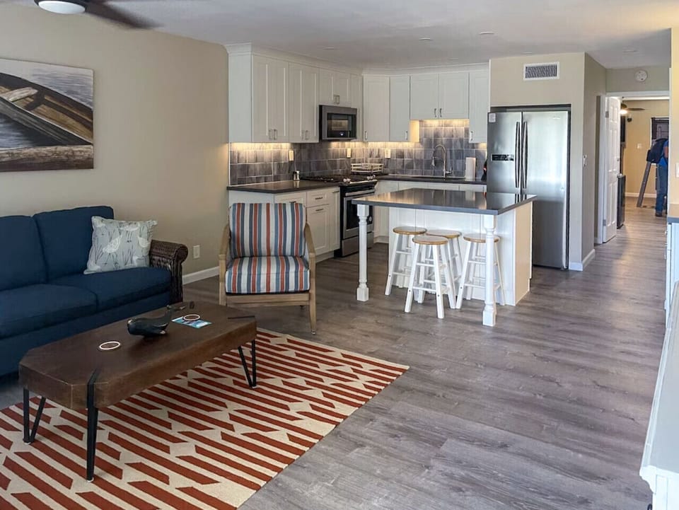 The living room with flatscreen TV and cold AC, with the gorgeous kitchen in the background