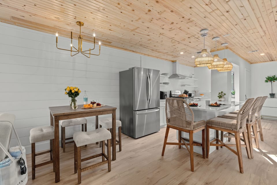 Dining area, a secondary view of the high-top table and the kitchen island beyond.