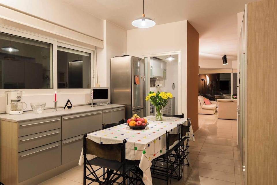 Functional kitchen with dining space and soft ambient lighting.