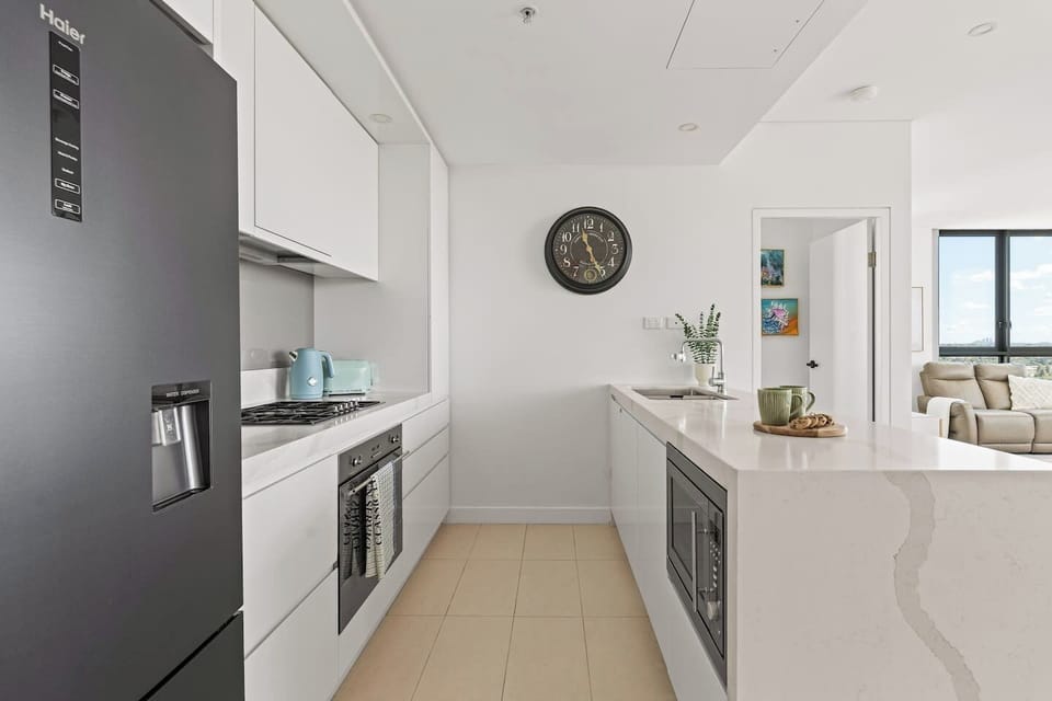 Prepare meals with ease in the modern gourmet kitchen featuring stone benchtops and quality appliances.