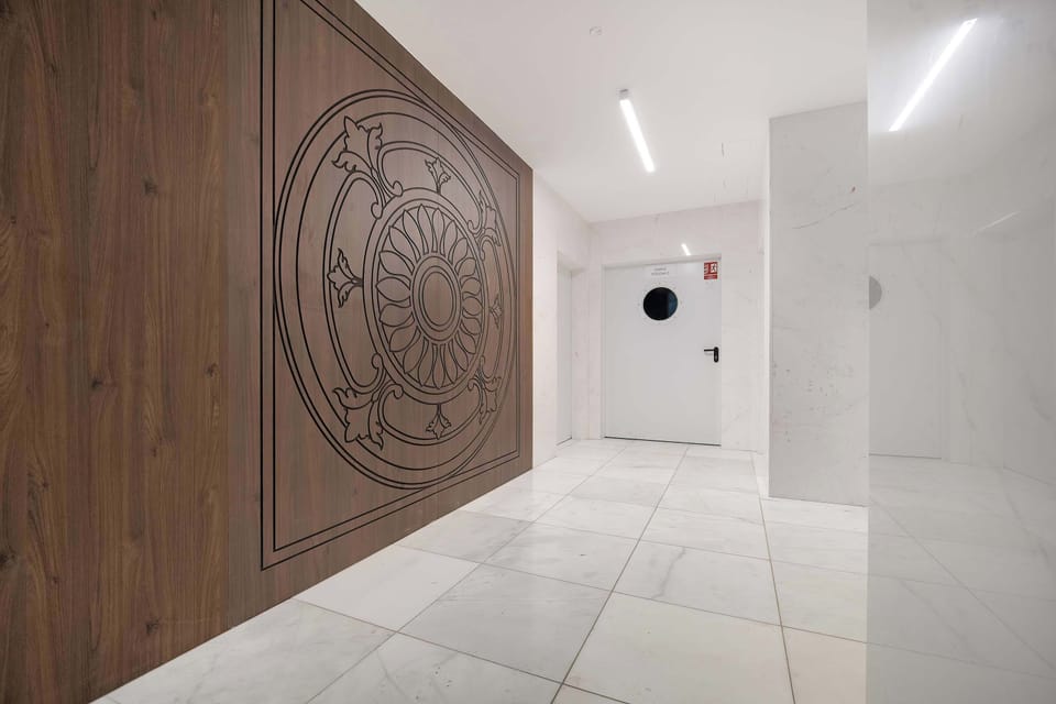 The building's interior hallway features a unique, large wooden circular decorative element on the wall.