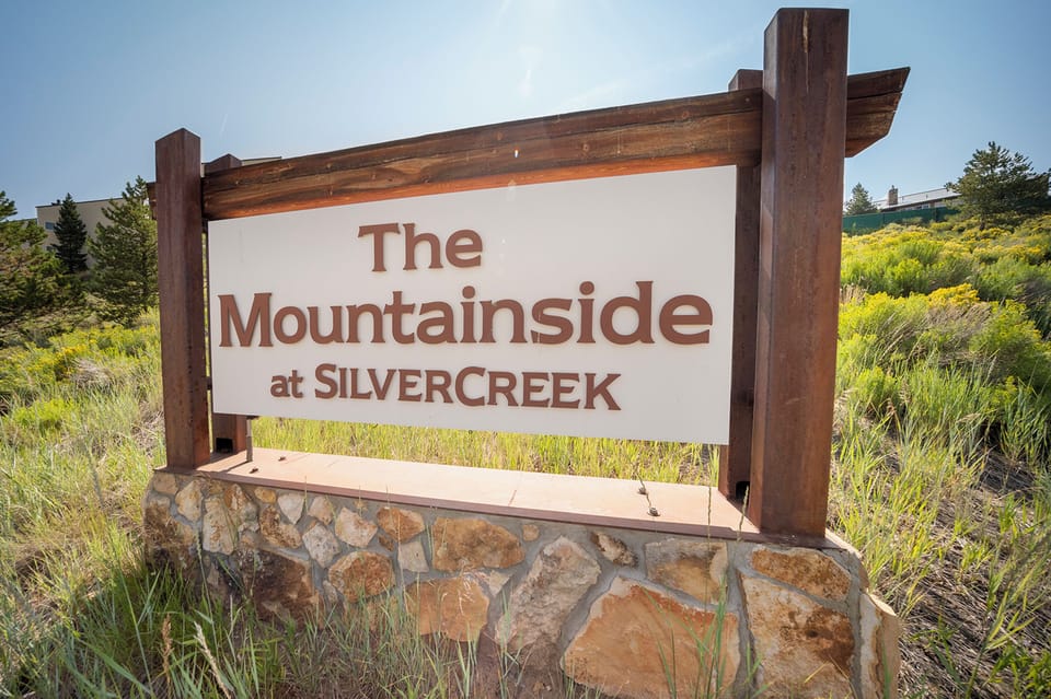 Property entrance sign for The Mountainside at Silvercreek surrounded by natural mountain landscape and native vegetation.