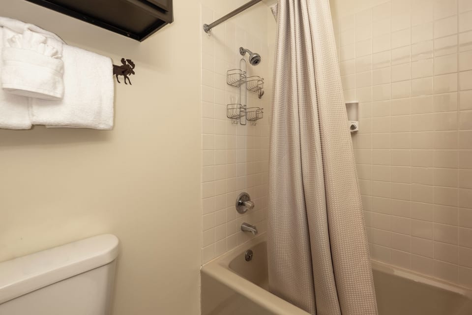 Your private bathroom at Mountainside Unit B-8 features fresh towels and a relaxing tub-shower combo for unwinding after mountain adventures.
