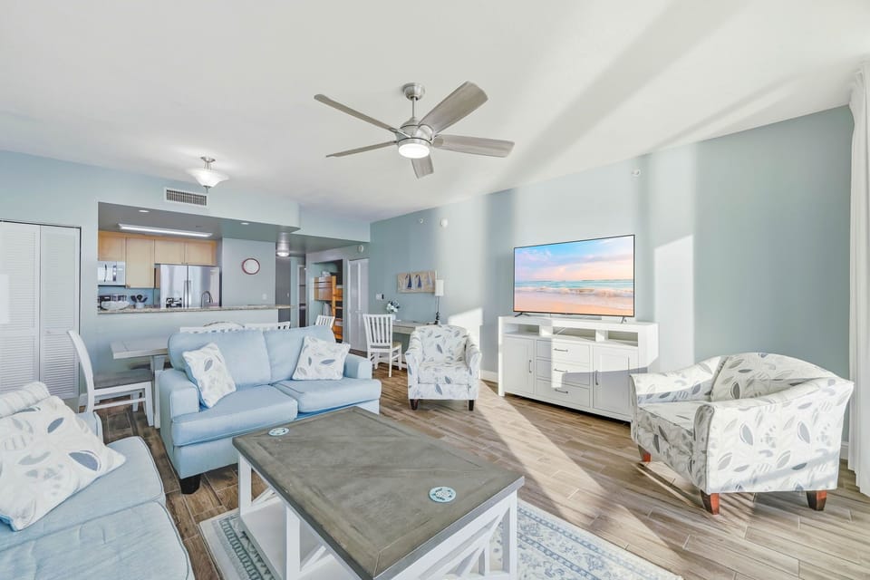 Bright living room with modern furnishings and a large flat-screen television.
