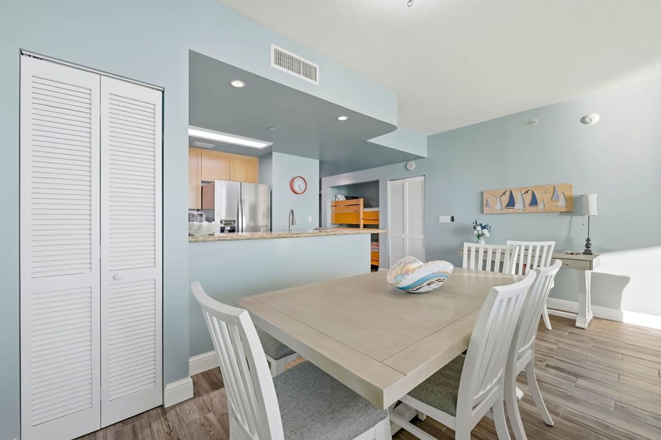 Dining area with coastal decor adjacent to a modern kitchen.