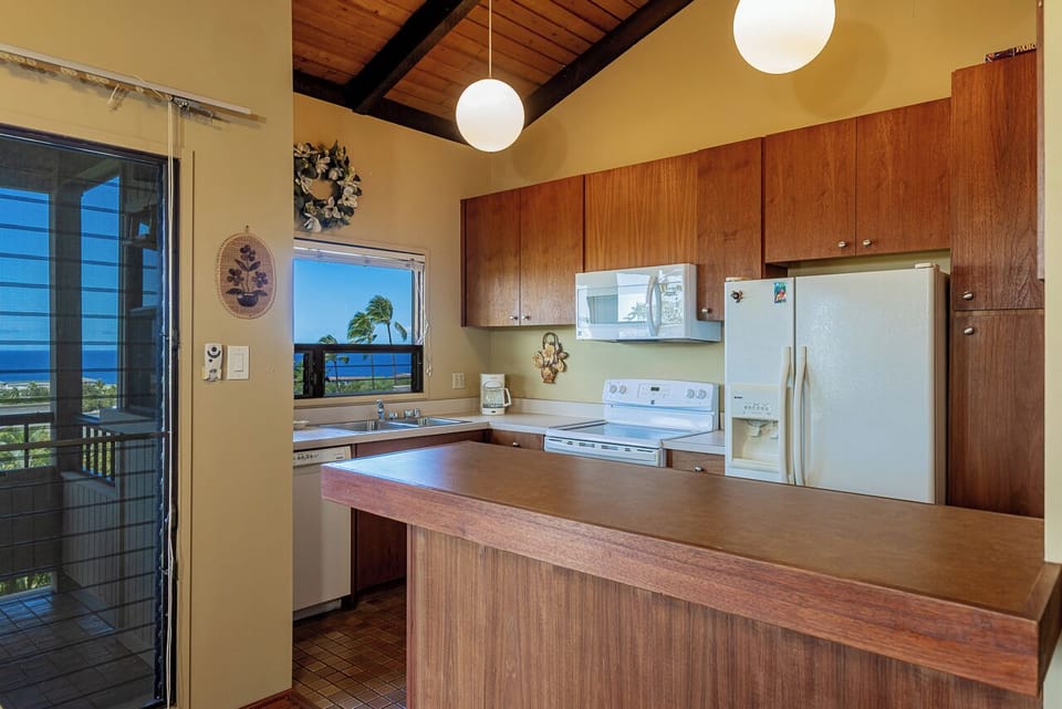 Your fully equipped kitchen features modern appliances, perfect for preparing meals while enjoying ocean views through the window.