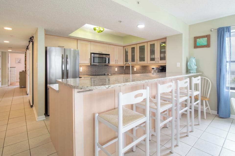 Your modern kitchen features granite countertops, stainless steel appliances, and a breakfast bar perfect for casual meals or morning coffee.