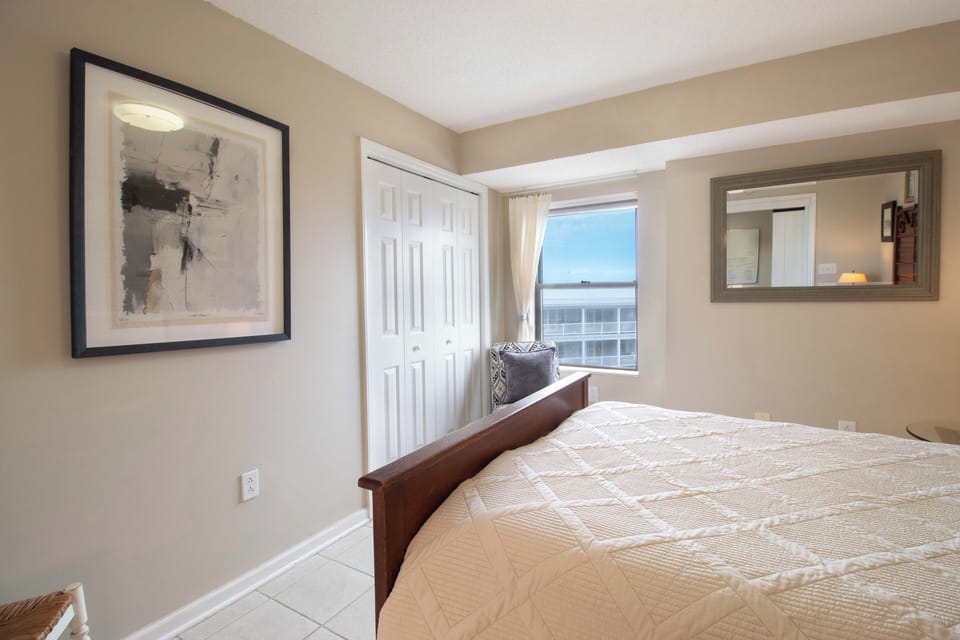 Wake up to stunning city views from your comfortable bedroom, where neutral tones and thoughtful artwork create a peaceful retreat.