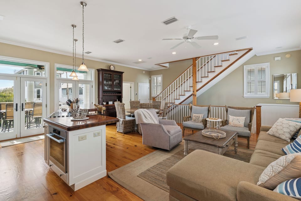 Relax in your spacious open-concept living area with gleaming hardwood floors, cozy seating, and a chef's kitchen island perfect for gathering.