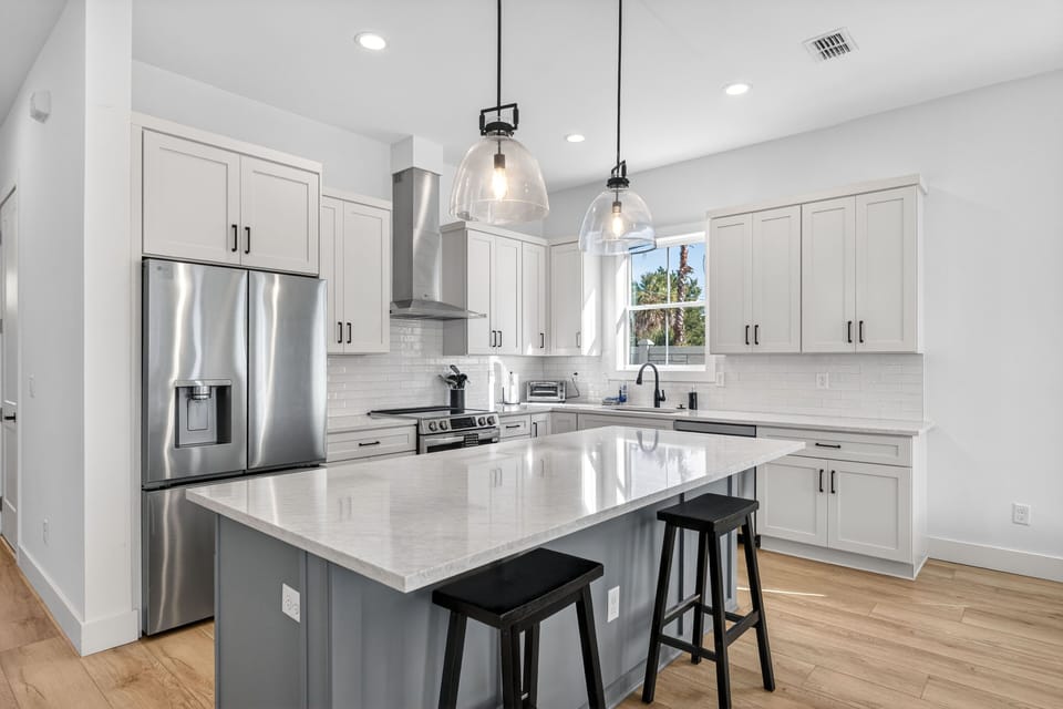 This sleek kitchen invites culinary adventures with crisp cabinetry and gleaming surfaces.