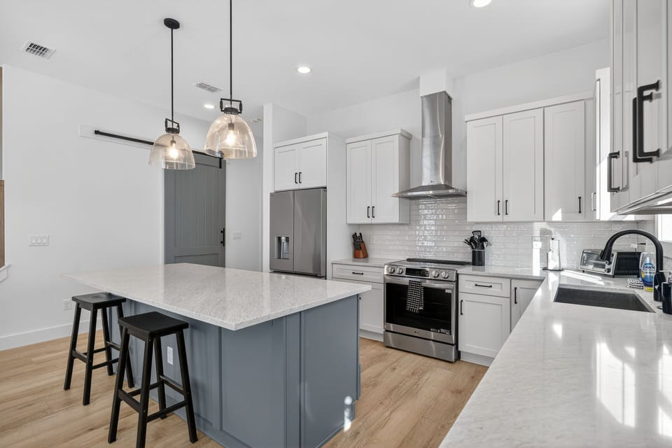 Contemporary pendant lighting and sleek finishes set the stage for effortless vacation cooking.