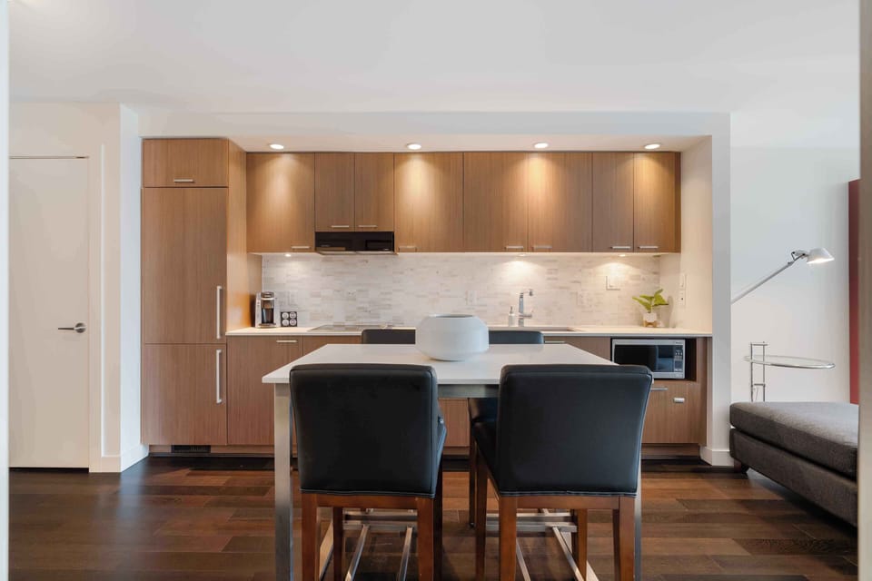 Modern dining area set in front of the fully equipped kitchen, perfect for enjoying meals in a stylish open-concept space.