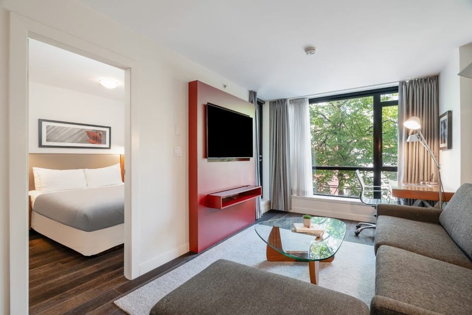 This thoughtfully designed suite offers a seamless flow between the living and sleeping areas, accented by a vibrant color palette and ample light for an inviting atmosphere.