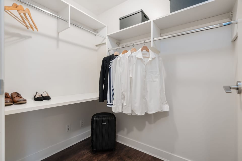 The spacious walk-in closet is designed for functionality, featuring a structured shelving system and hanging space, ensuring plenty of room for all your wardrobe essentials.