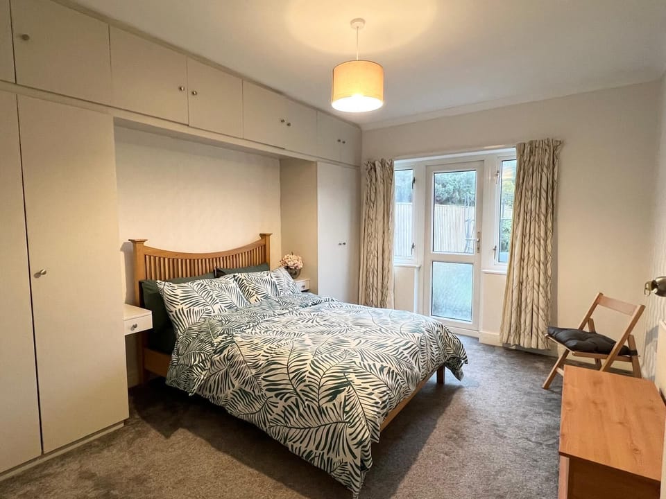 Main bedroom with JL queen bed and direct access to garden and computer table.