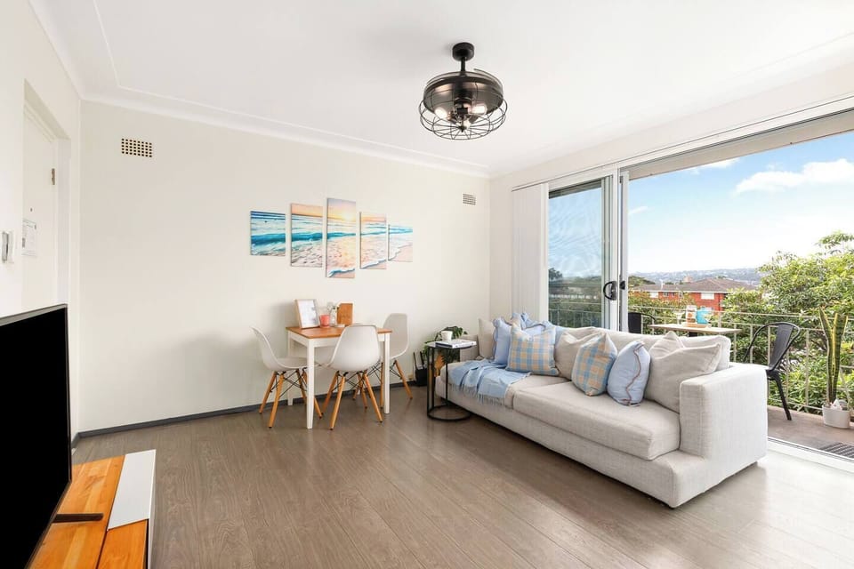 Settle into the sunlit living area with comfortable seating and a TV, perfect for unwinding after a day out or enjoying an easy night in.