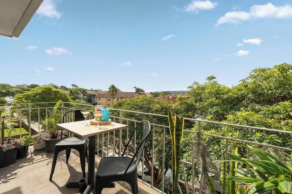 A private balcony with outdoor seating offers leafy views and a quiet spot for morning coffee or a drink at the end of the day.