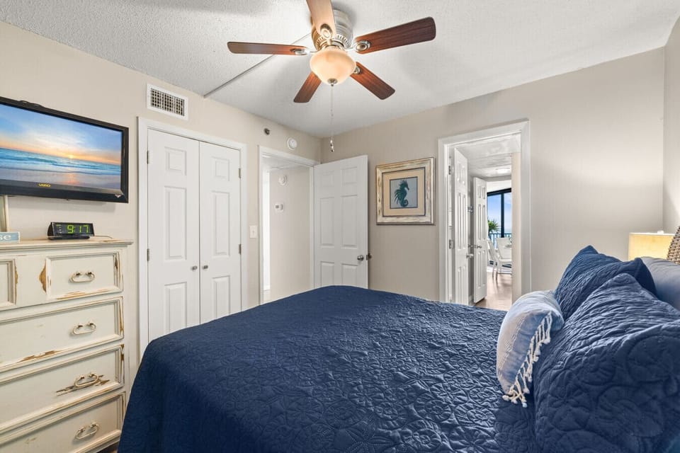 pacious bedroom with Smart TV, ample storage, and easy access to the living area