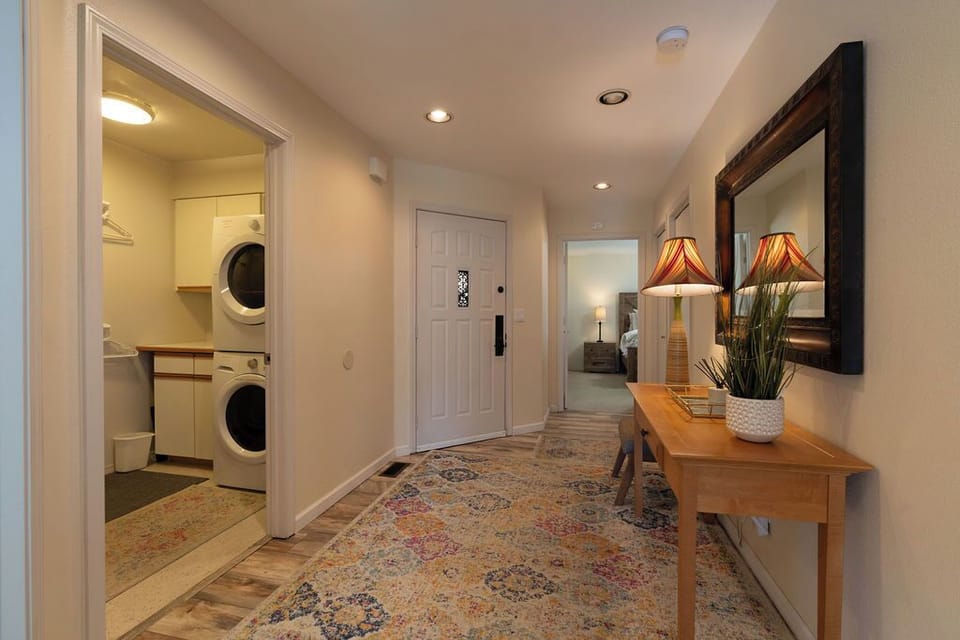 Hallway with view of laundry room, front door, and Main bedroom entry