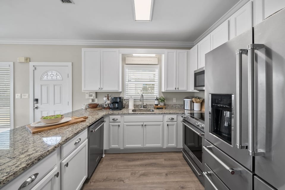 The bright, open kitchen features granite countertops and new appliances.