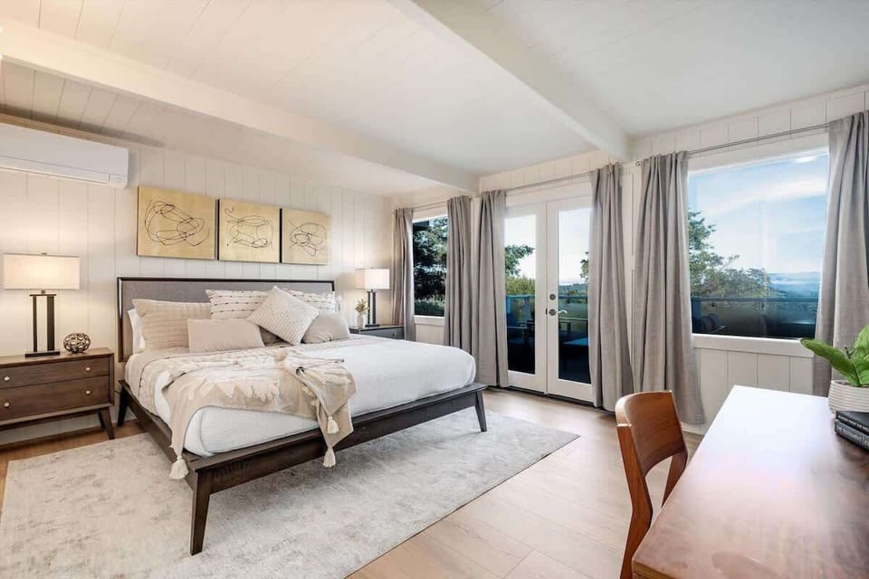Sunlit master bedroom with serene mountain views and cozy elegance