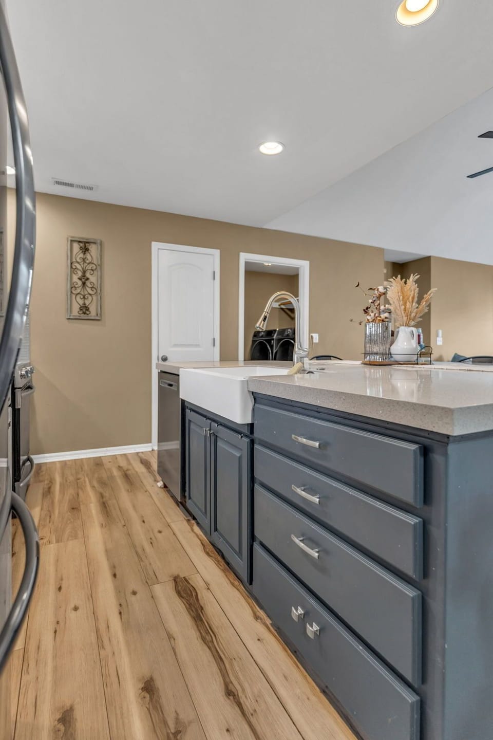 Large kitchen island with farmhouse sink and open layout for gathering.