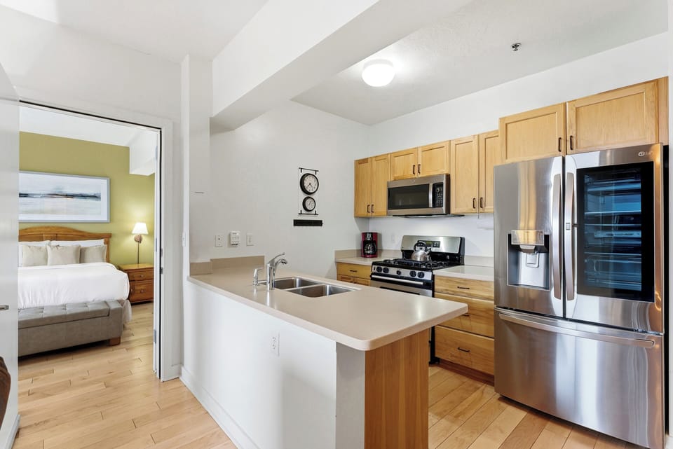 Modern Kitchen with Stainless Steel Appliances:
Updated kitchen with stainless steel refrigerator, granite countertops, wood cabinetry, and breakfast bar seating.