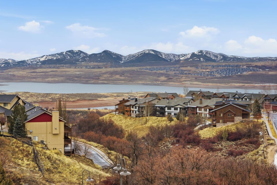 Panoramic Mountain and Lake Views:
Scenic view of alpine mountains, lake, and luxury residences surrounded by vibrant fall foliage.
