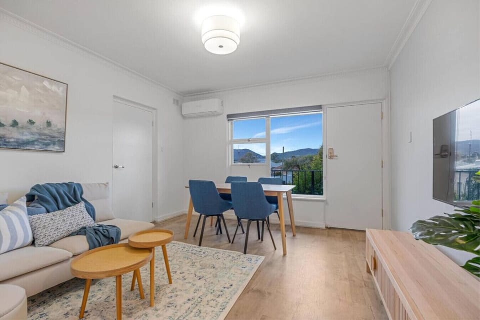 Open living and dining area with natural light, Smart TV, and balcony access.