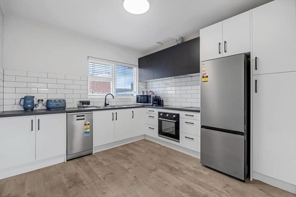 Fully equipped modern kitchen with induction cooktop, oven, dishwasher, and all essentials for easy meals.