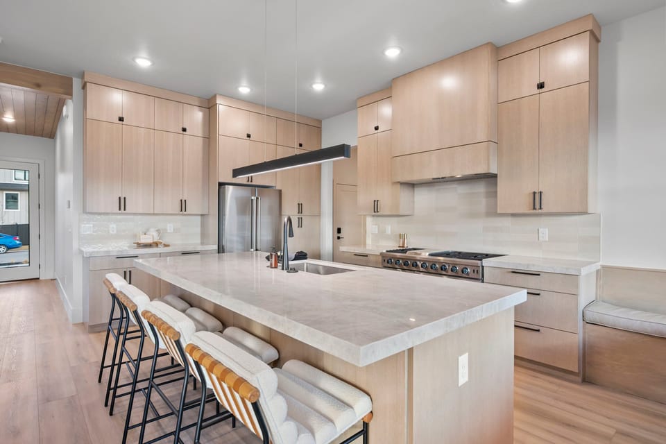 A large well appointed chef's kitchen with massive island, additional seating, butlers pantry, and high end appliances