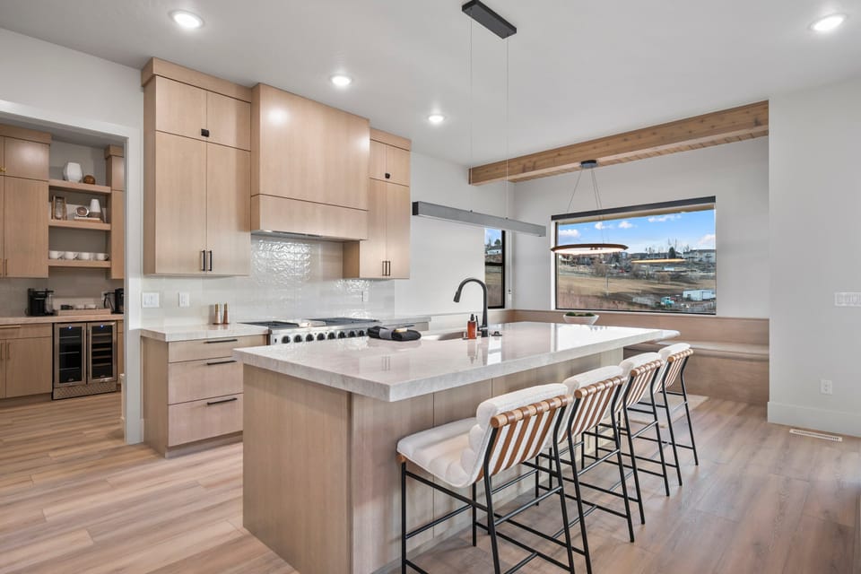 A large well appointed chef's kitchen with massive island, additional seating, butlers pantry, and high end appliances