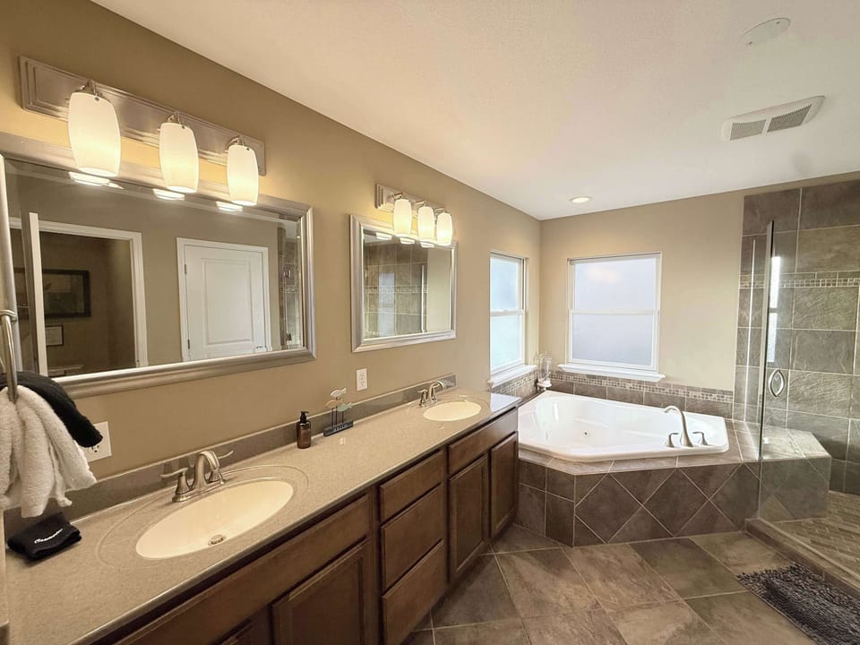A double vanity, Jacuzzi tub, & shower await in this king ensuite​