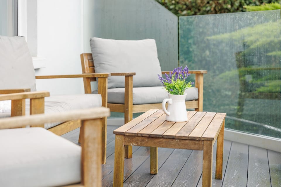 Enjoy balcony seating at Cowes Garden Apartment with comfortable chairs and scenic sea and garden views - ideal for relaxation and alfresco dining.