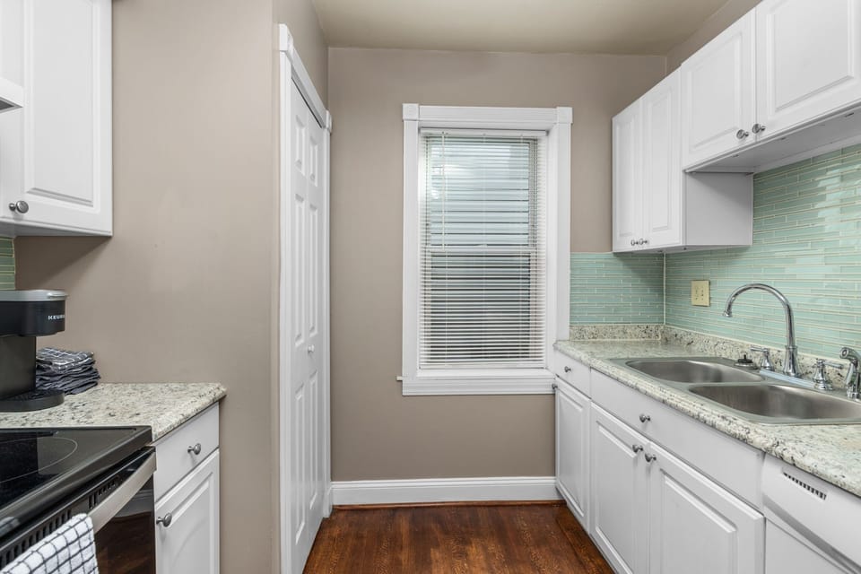 Updated kitchen with white cabinetry and stainless steel appliances