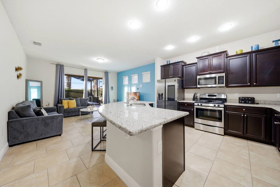 Welcome to a bright kitchen with elegant dark wood cabinetry and a stunning granite island for casual meals. The cozy seating area invites relaxation, and large windows enhance the inviting ambiance with lovely views.