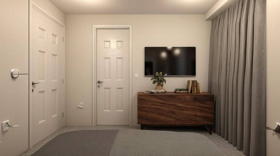 Welcome to a cozy retreat with a stylish wooden cabinet and a soft gray carpet. The calming gray curtains surround a flat-screen TV, offering a perfect space to relax and unwind after your day's adventures.