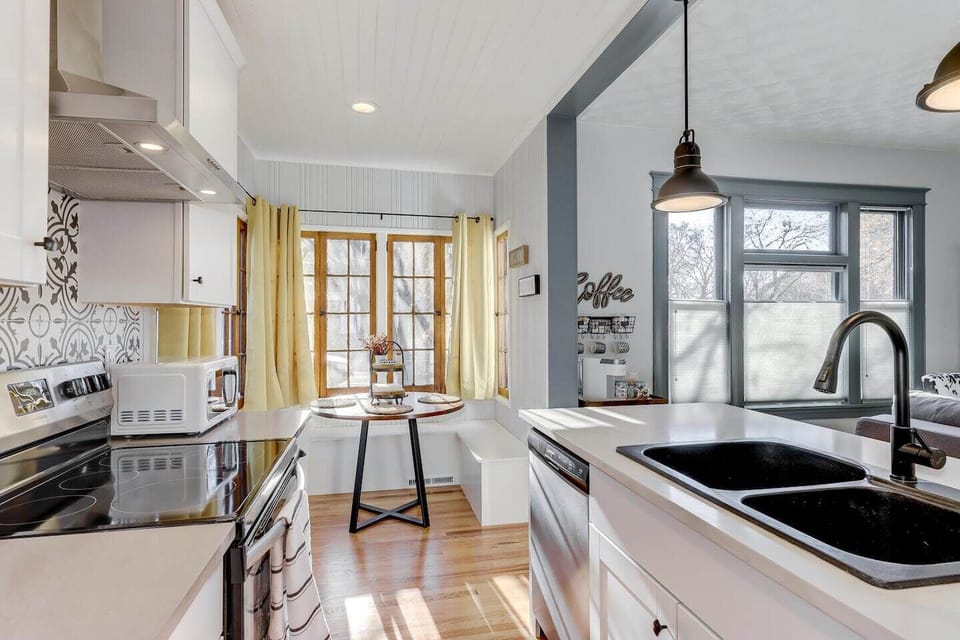 Well lit kitchen banquet dining area with beautiful views of neighborhood.  