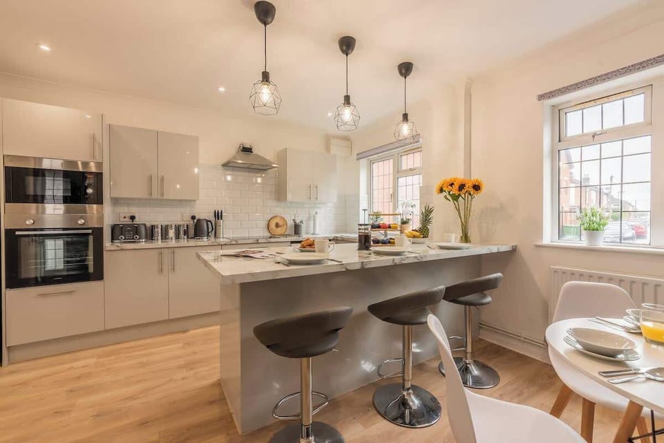 Light and bright kitchen space with oven, microwave, kettle, dishwasher, washer/dryer and electric hob at Blue Puffin Stays Short Lets & Serviced Accommodation