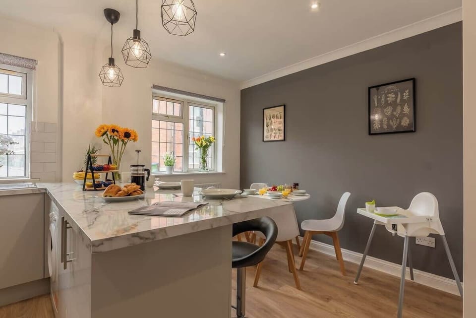 Plenty of cushions and throws for maximum comfort in the living area. There is a door leading to the conservatory and garden. TV present on opposite wall at Blue Puffin Stays Short Lets & Serviced Accommodation