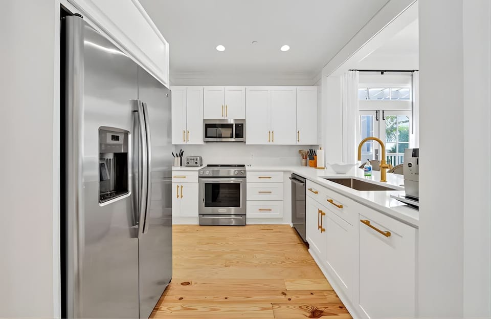 Chef’s kitchen featuring pristine white cabinetry and professional-grade appliances.