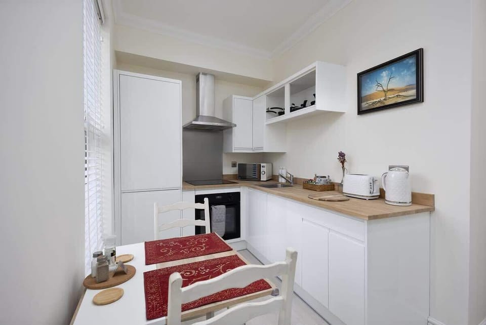 Whip up your favorite meals in this bright, all-white kitchen. Compact yet fully equipped with modern appliances. Perfect for cozy breakfasts, home-cooked dinners, or a coffee break in style.